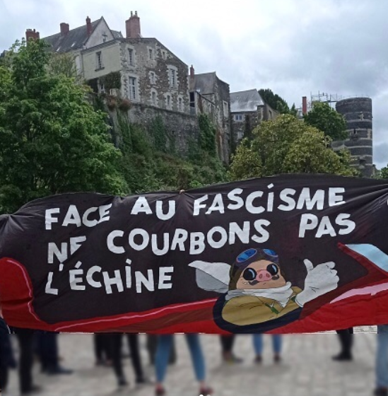 Groupe de manifestant.es derrière une banderole avec le personnage porco rosso où il est écrit "Face au fascisme ne courbons pas l'échine".